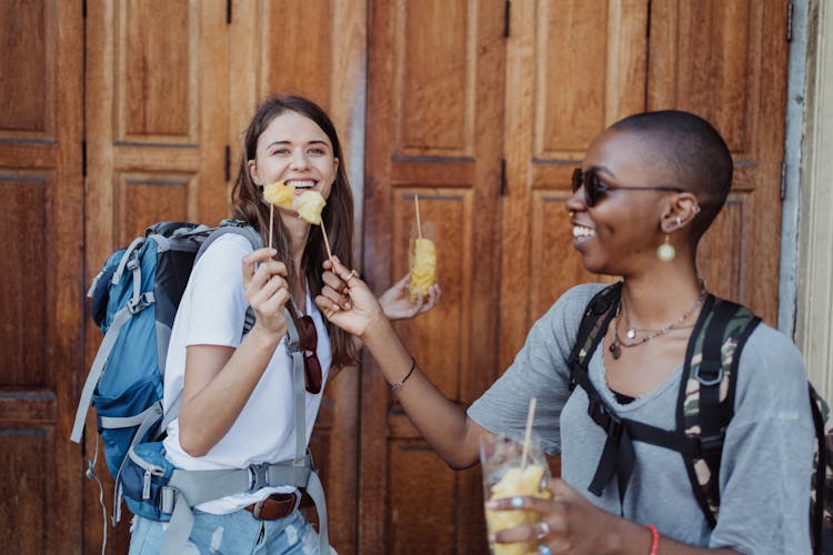 Smiling Women Eating Street Food