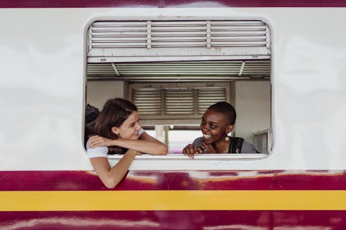 Smiling Women Sitting Beside a Train Window