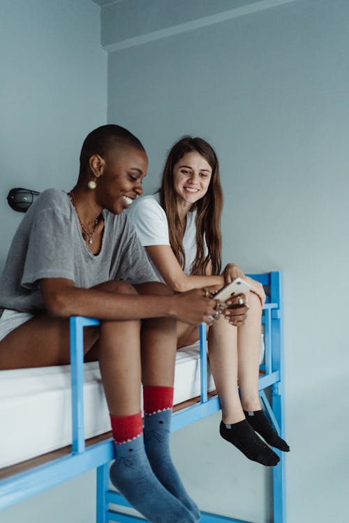 Smiling Women Sitting on a Bed