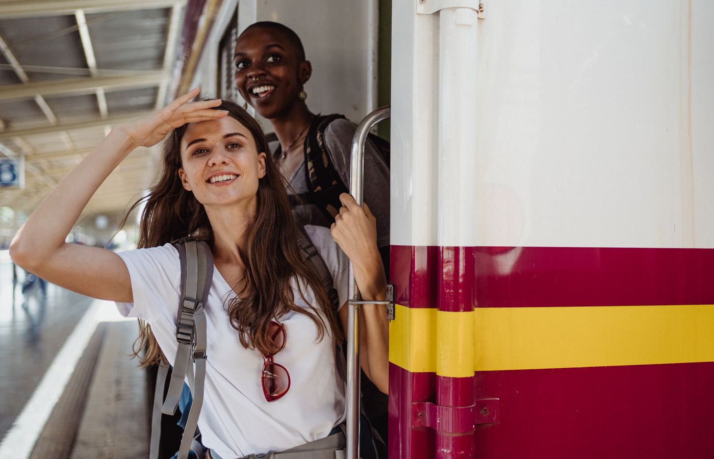 Two friends eagerly embark on a train journey, capturing the joy of travel.