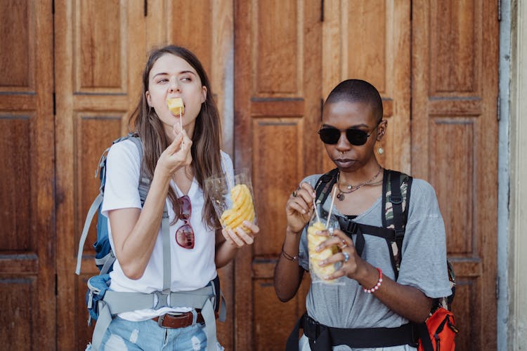 Women Backpackers Eating A Snack Outdoors 