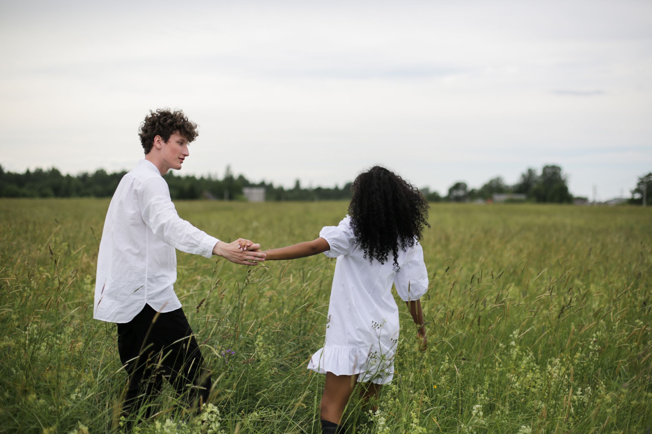 Man and Woman Holding Hands While Walking on Green Grass Field · Free ...