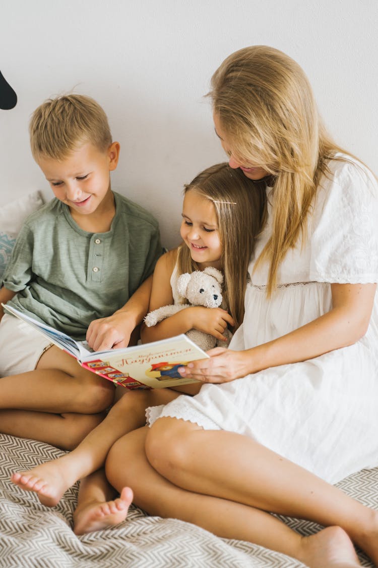 A Woman With Her Children Reading Books Together