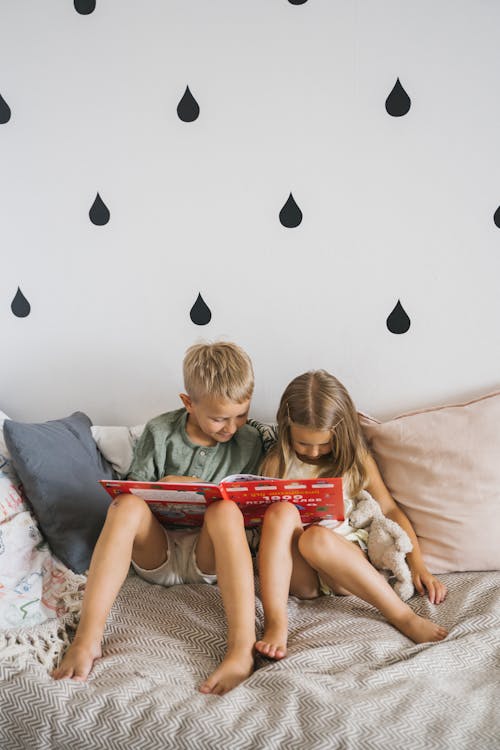 A Brother and Sister Reading a Book Together 