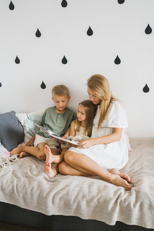 Woman and Her Kids Reading a Book