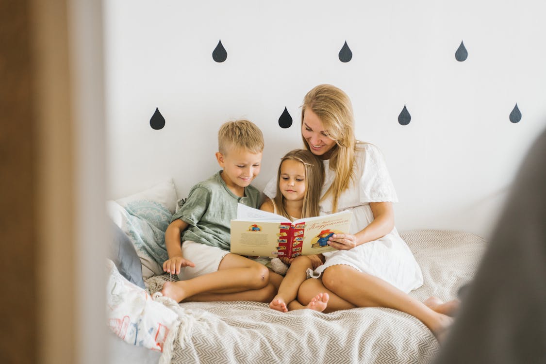 Free Kids and a Woman Reading Book Stock Photo