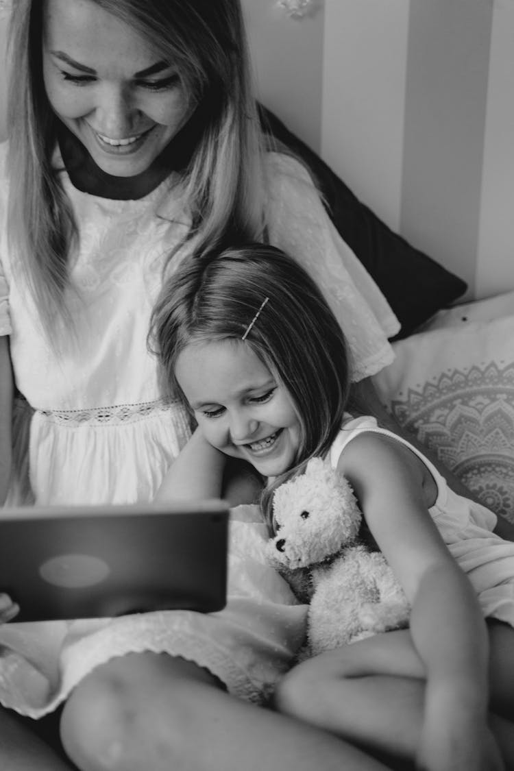 Grayscale Photo Of A Mother And Her Child Watching On A Tablet