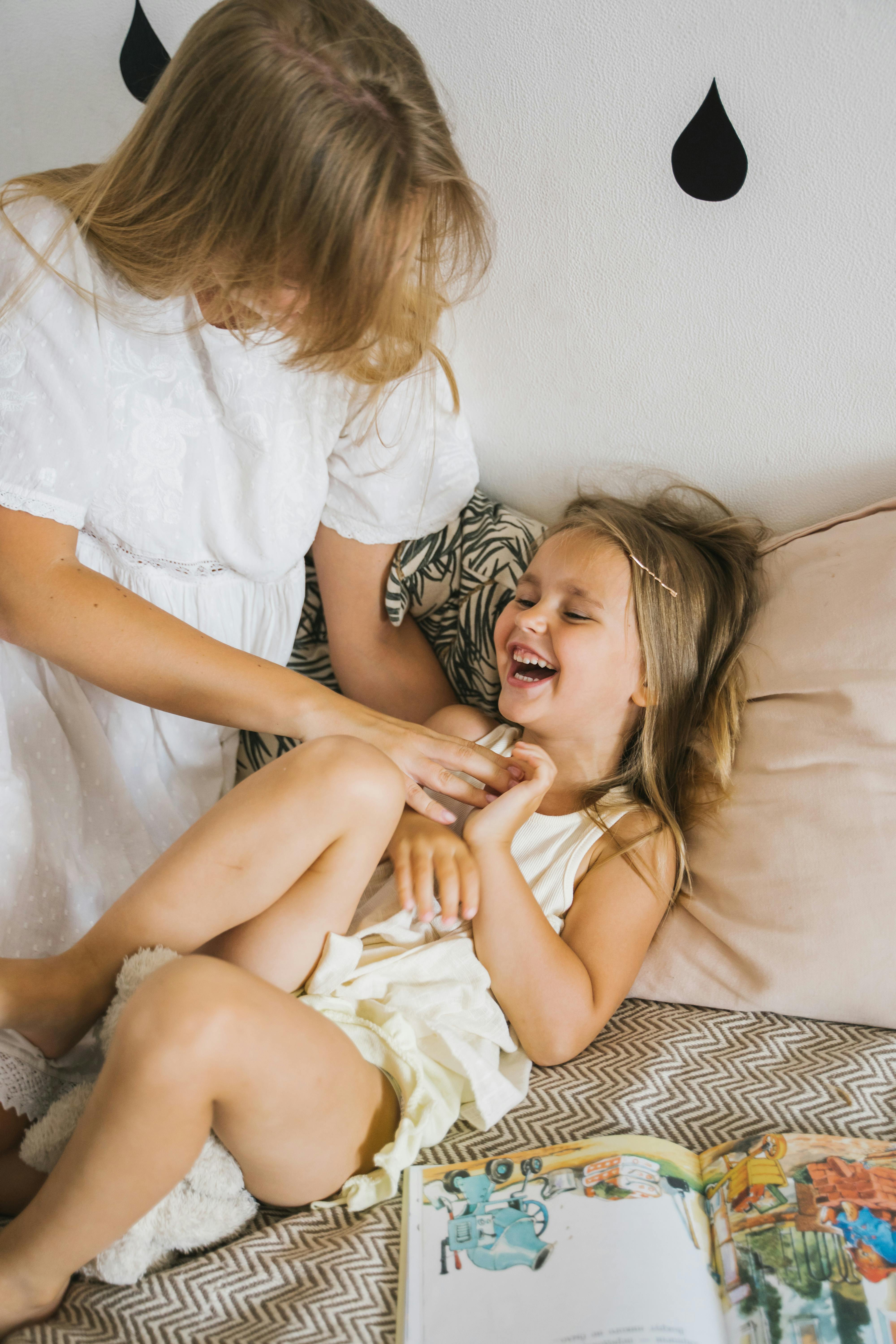 photo of a mother tickling her child