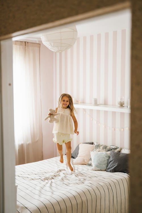 Free A Girl Jumping on the Bed Stock Photo