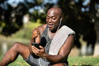 在户外运动后，微笑的人用智能手机庆祝