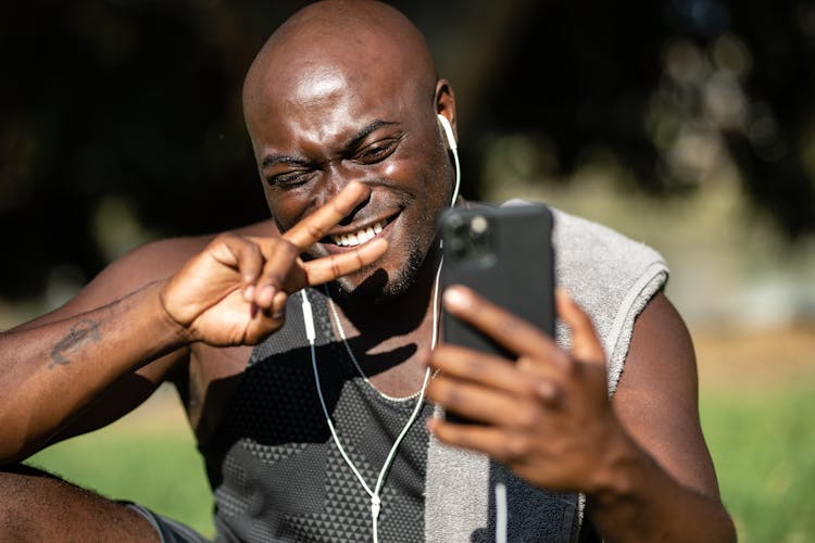 Man Showing A Peace Sign Over The Phone