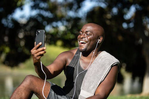 Man Laughing While Holding a Cellphone