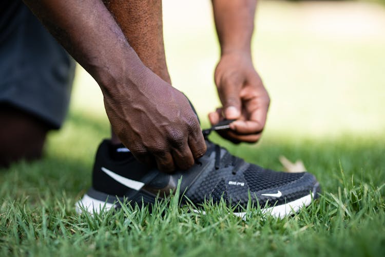 Close Up Photo Of A Person Tying Shoelaces