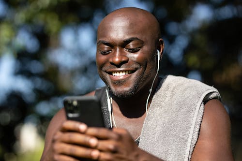 Free Man Smiling While Holding Cellphone Stock Photo