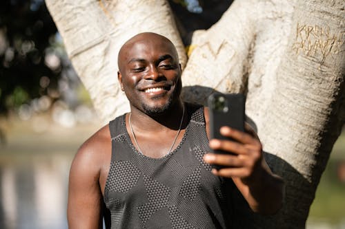 Free Man Smiling While Holding Cellphone Stock Photo