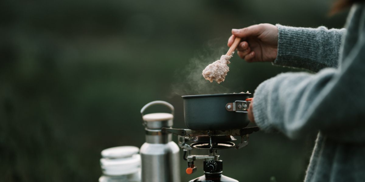 Préparation d’un porridge chaud sur un réchaud de camping en pleine nature