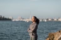 一个女人在海滨闭着眼睛，享受户外的放松时刻