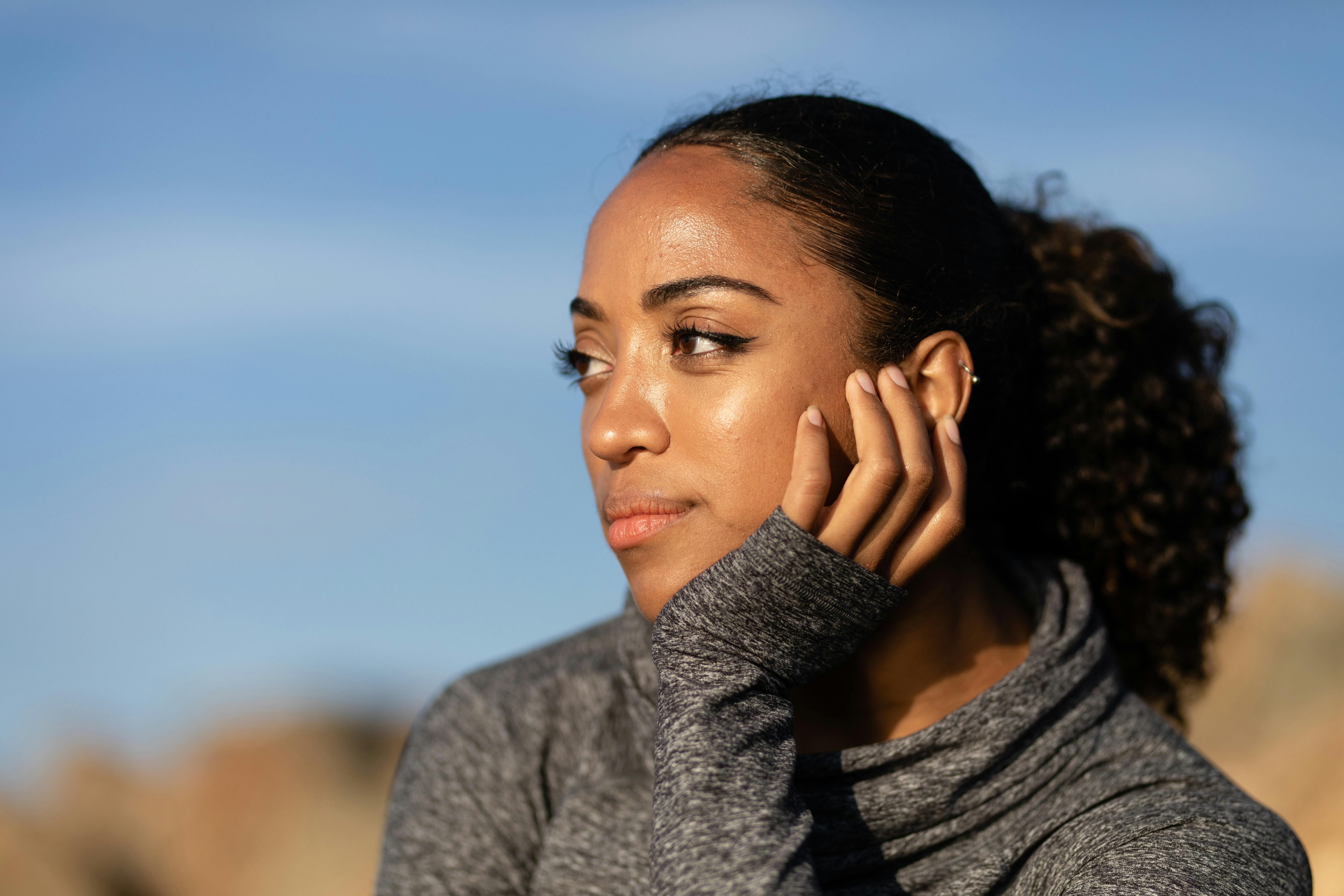 close up of a woman posing with her hand on her chin