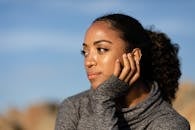 一个女人在阳光下，手托着头，露出沉思的表情