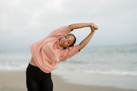 一名女子在海滩上做瑜伽姿势，促进健身和正念