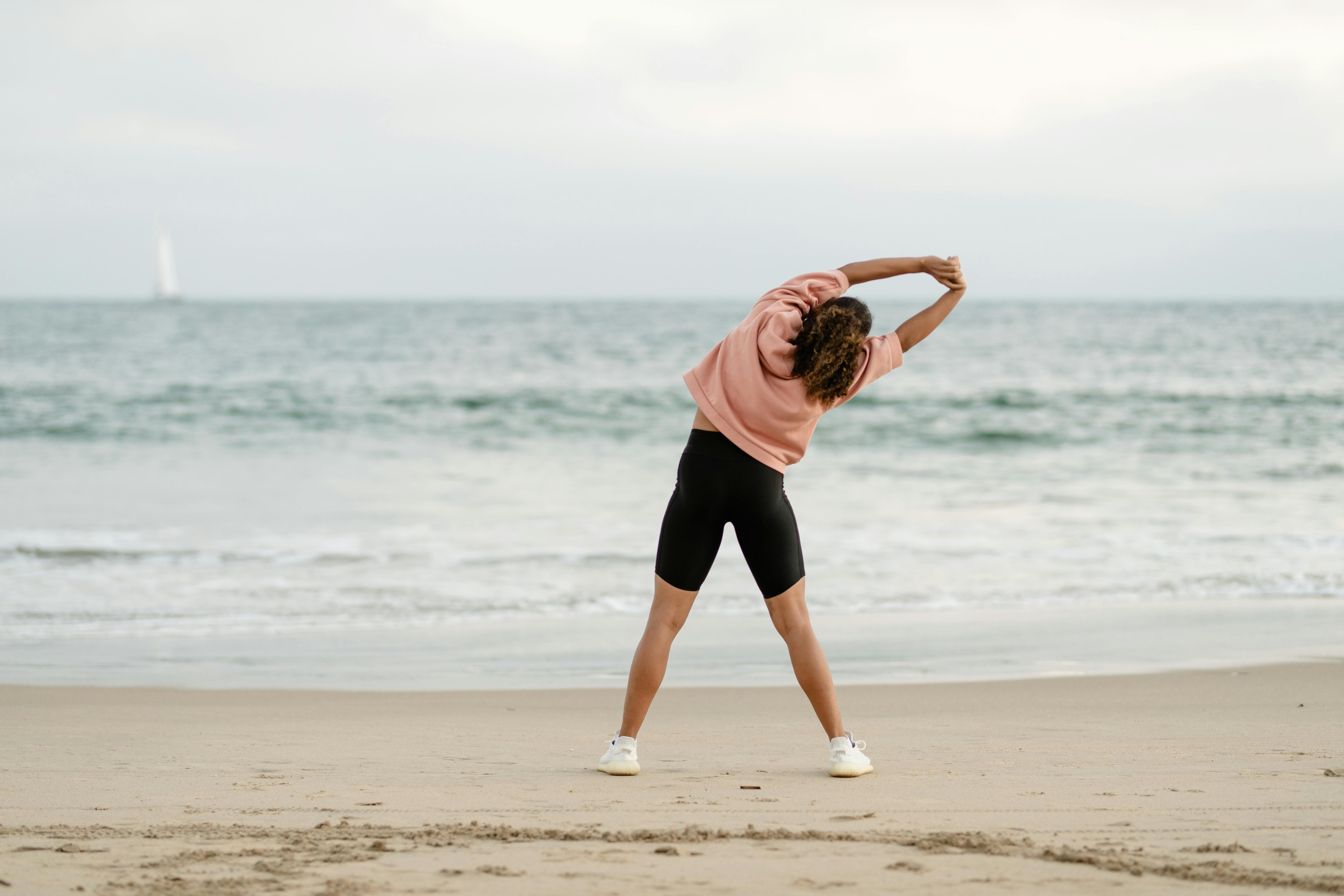 Tourist in a Two-Piece Swimsuit on a Pebble Beach Taking Off Shirt