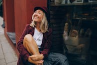 一位快乐的女士坐在面包店的窗边，享受着轻松的城市氛围