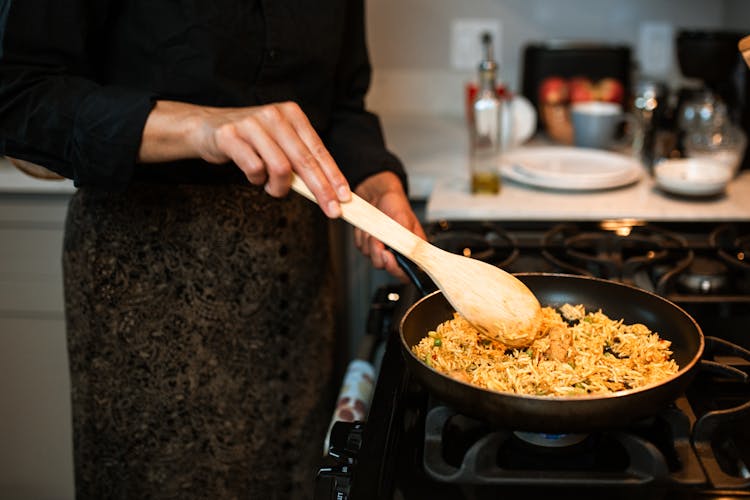 A Person Cooking A Rice Dish