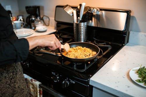 Free A Person Cooking a Rice Dish Stock Photo