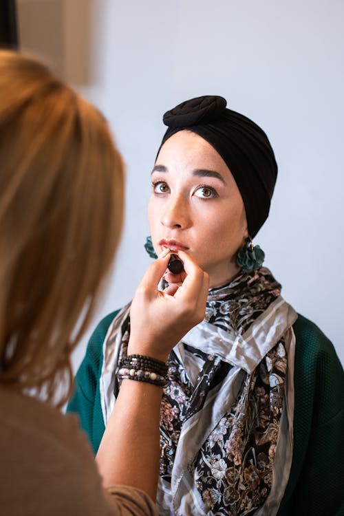 A Makeup Artist Applying Lipstick on a Woman