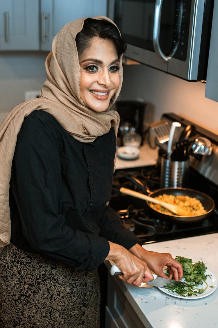 A Woman Chopping Cilantro On A Plate