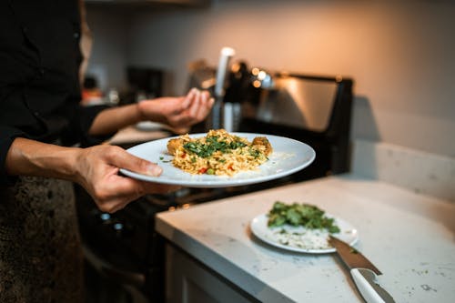 Person Holding White Ceramic Plate With Green Vegetable Dish