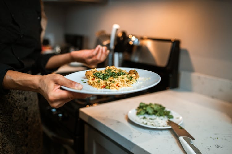 A Person Holding A Plate Of Food