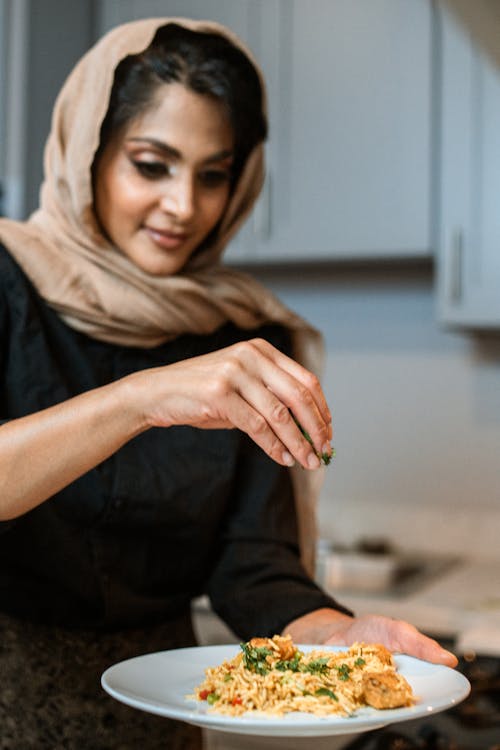 Une Femme Saupoudrant Du Persil Sur Un Plat