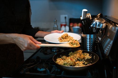 A Person Putting Fried Rice on a Plate