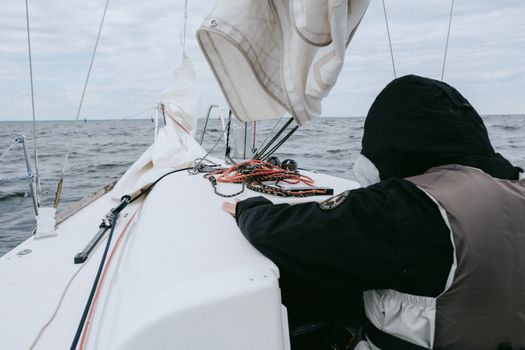 Person in Black Pants Sitting on White Boat
