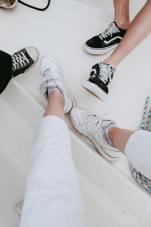 Free Group of people enjoying a casual boating trip, showcasing their footwear styles. Stock Photo