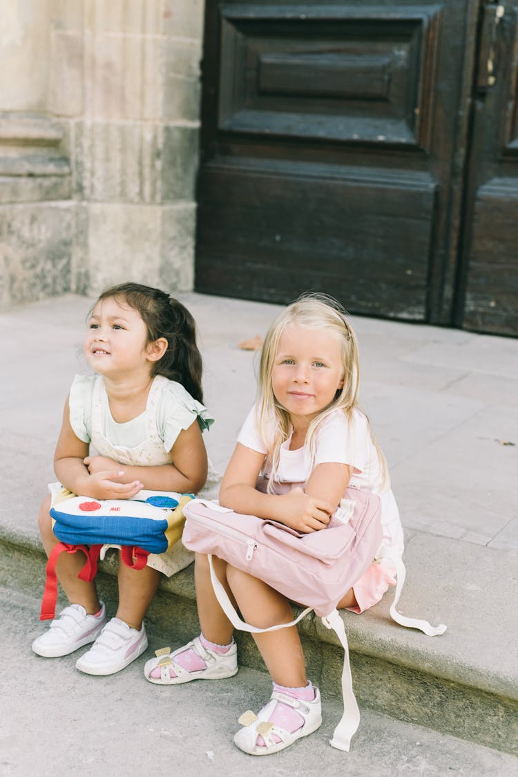 Young Girls Sitting On The Curb