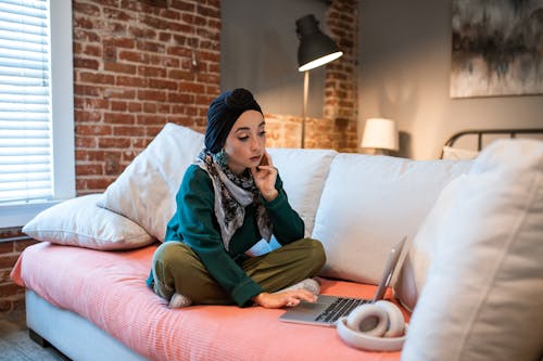 Free Woman using Laptop on Couch Stock Photo