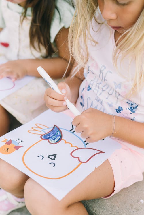 Close-up Photo of Girl drawing on Paper 