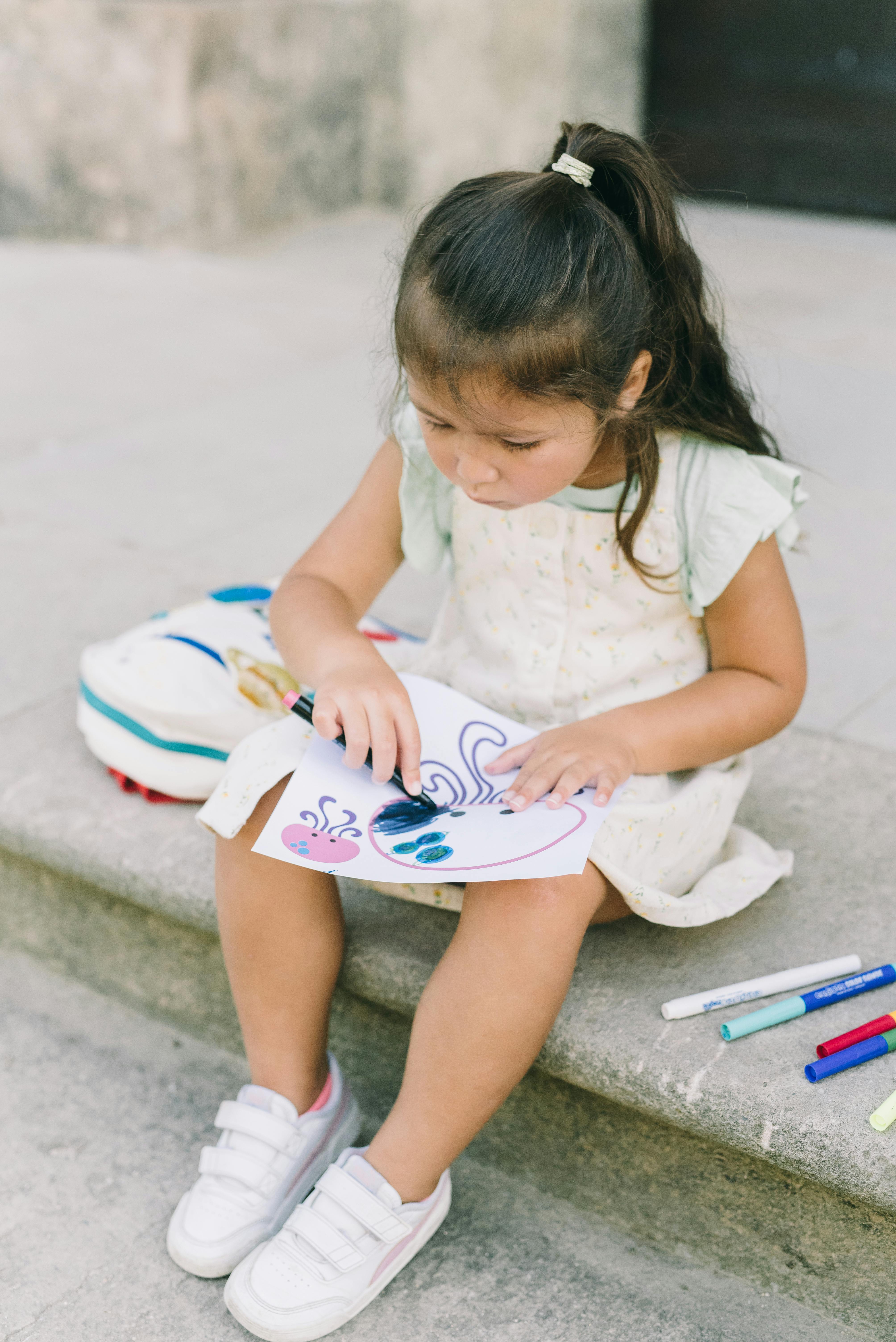 close up photo of girl drawing on paper