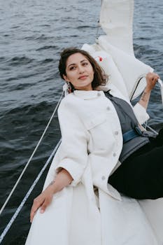 A woman enjoys a serene moment lying on a yacht with a view of the open sea.