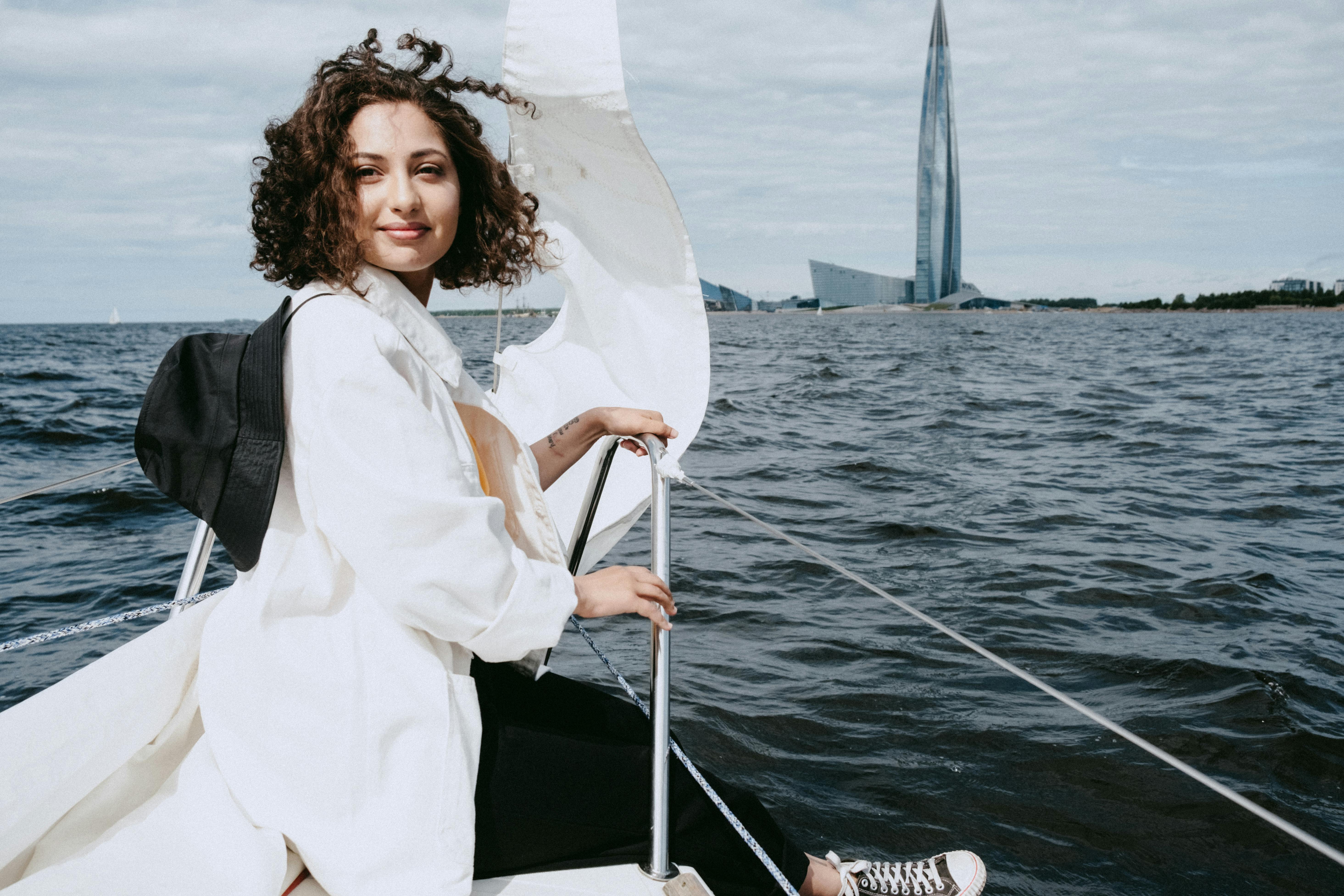 woman in white long sleeve shirt and black vest standing on boat