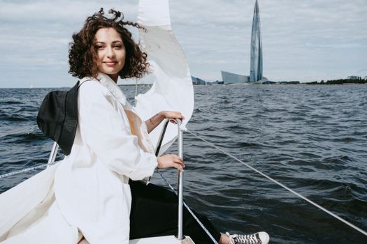女人乘船航行在现代摩天大楼附近，欣赏着海景
