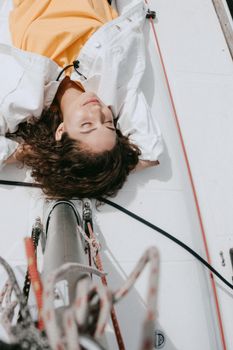 A woman enjoys sunbathing on a yacht, surrounded by nautical elements and blue skies.