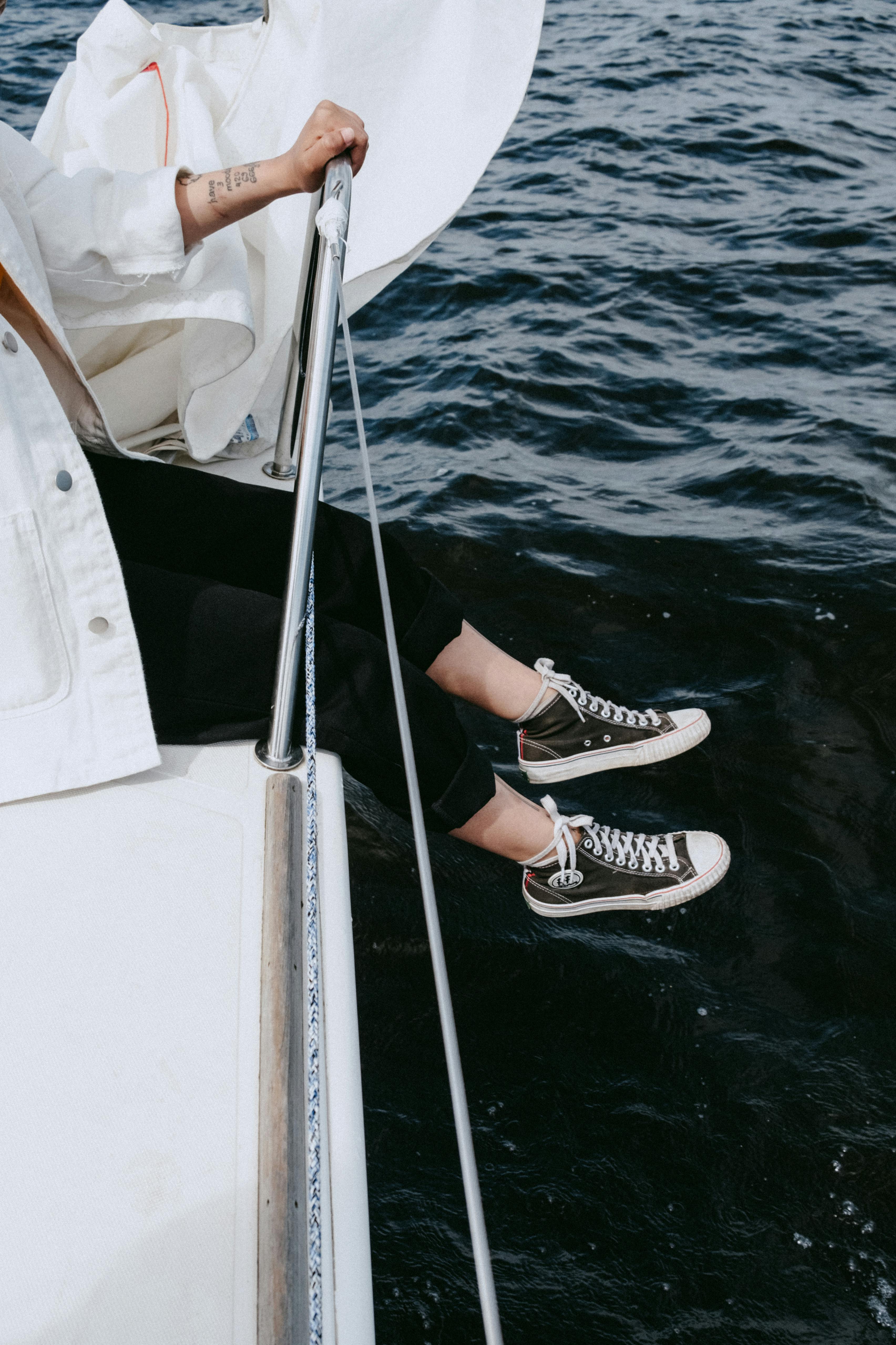 person in black and white sneakers on white boat