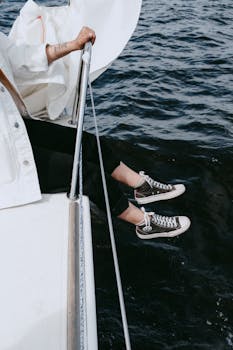 女人在游艇上放松，双腿悬空，享受大海