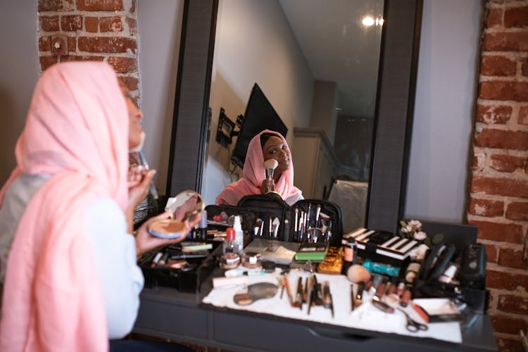 Woman In Pink Headscarf  Applying Blush On