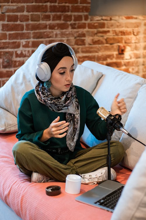 Vrouw In Groene En Bruine Hijab Zittend Op Wit Bed