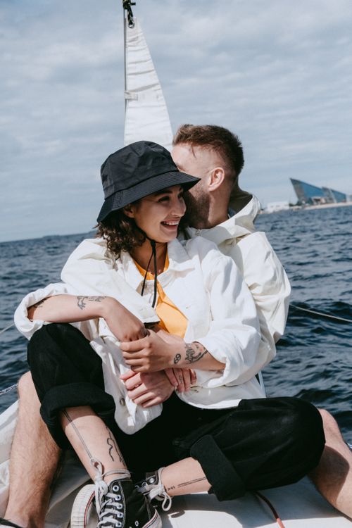 Free A couple enjoying a romantic sailboat ride on a sunny day by the sea. Stock Photo