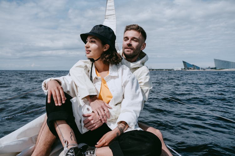 Man In White Dress Shirt And Woman In White Dress Shirt Sitting On Boat